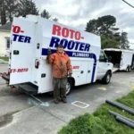 plumber in front of roto-rooter van